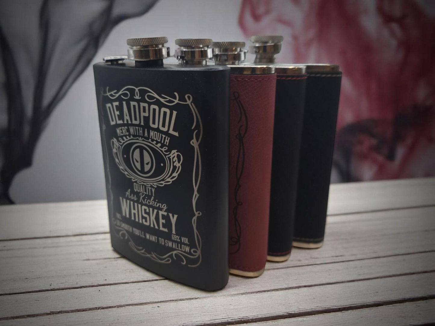 three flasks of liquor sitting on top of a wooden table