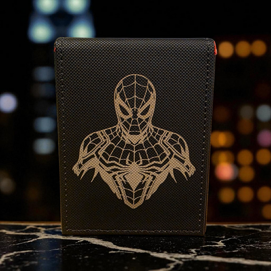 A black wallet or card case with a detailed Spiderman design printed on it, sitting on a marble surface.
