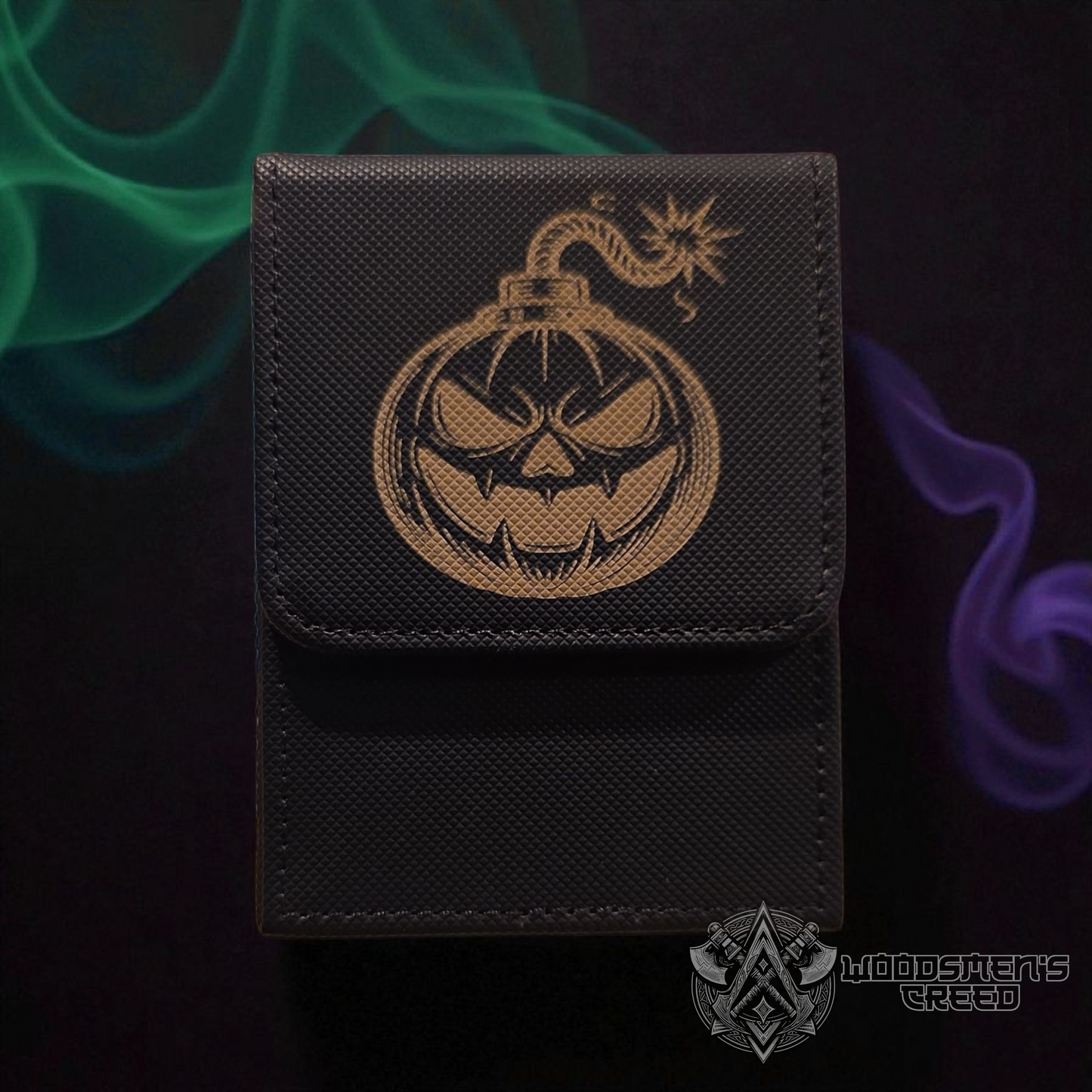 A black wallet with a gold pumpkin design on it, set against a dark background with green and purple smoke.