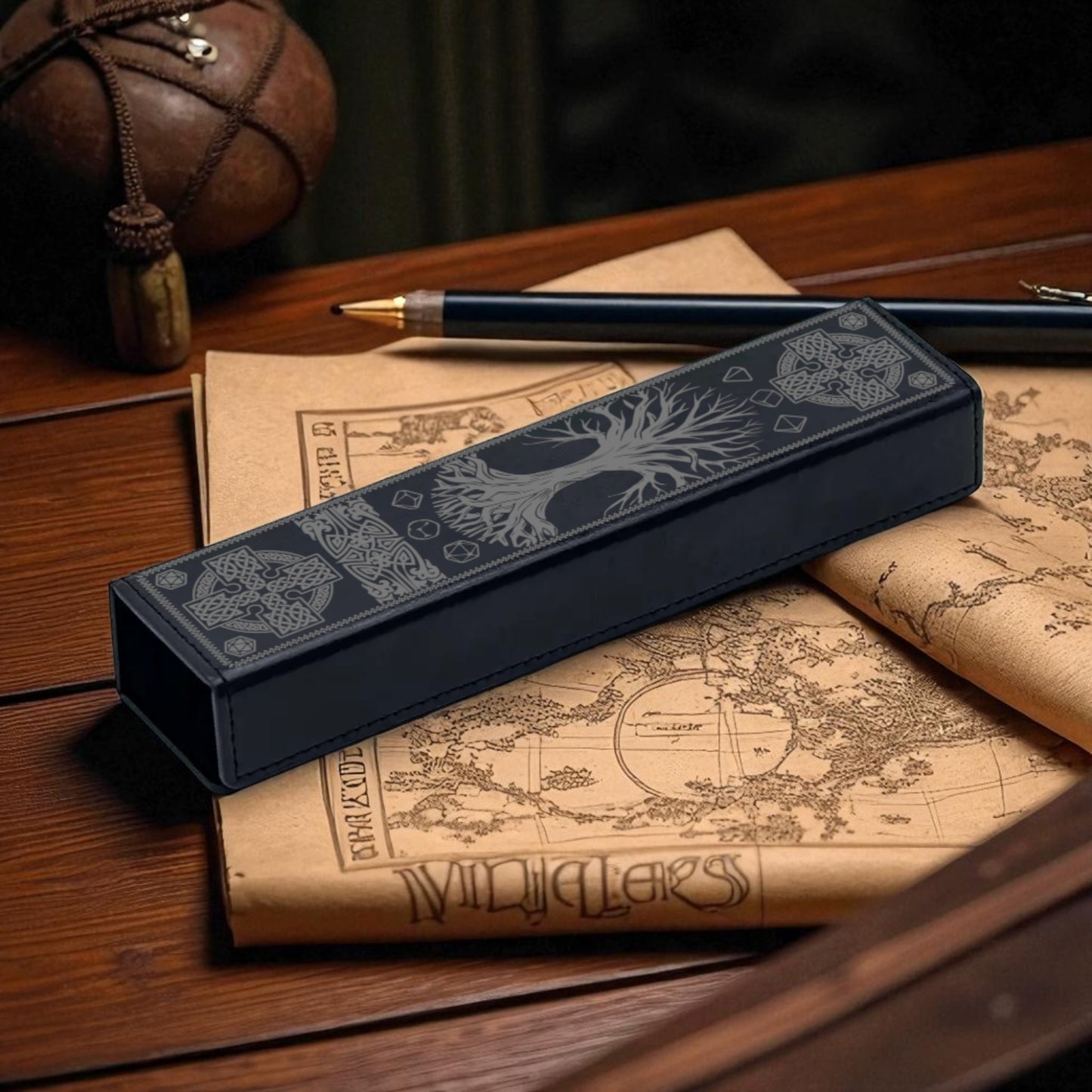 a pen, a map, and a box with a tree design on it, all placed on a wooden surface.
