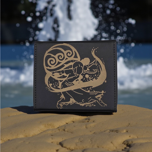 A black wallet with a gold design featuring a stylized figure on a beach, with water splashing in the background.