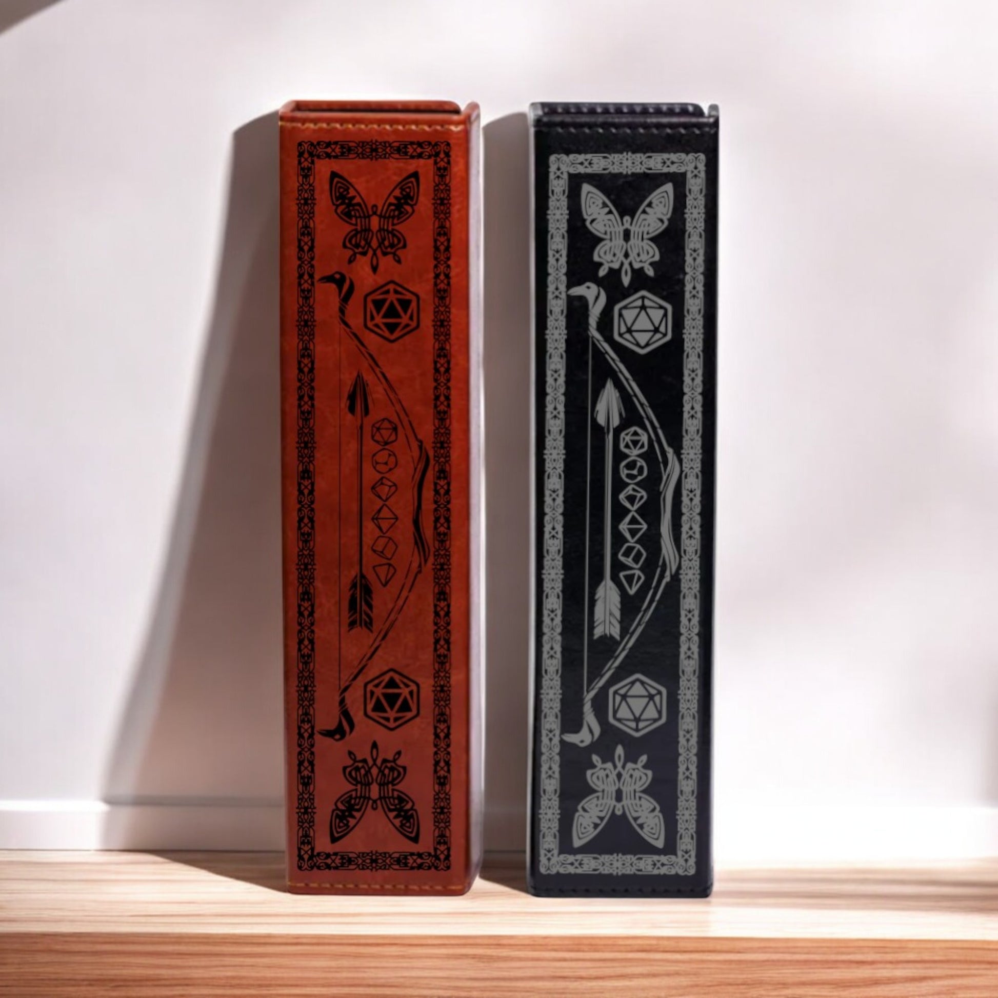 Two ornate, decorative bookends with intricate designs and patterns on their sides stand side by side against a white wall.