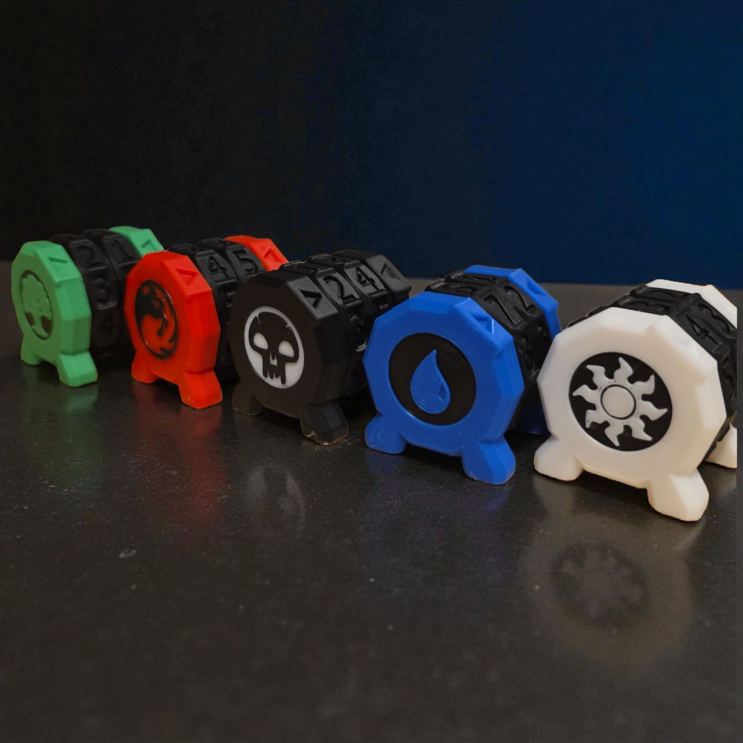 A row of five colorful plastic dice with various symbols on them, including a skull, a sun, and other abstract designs.