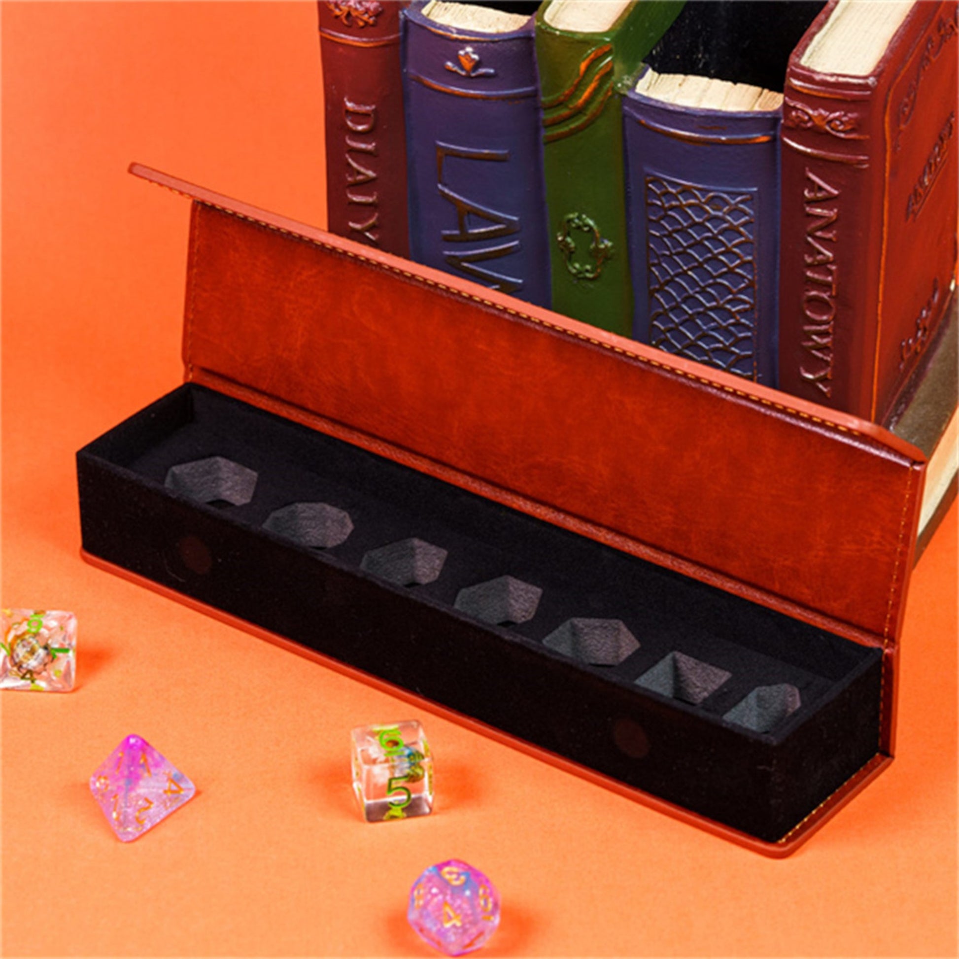 A red leather-bound book with the title "LAW" on the spine, placed next to a set of seven dice in a black box.
