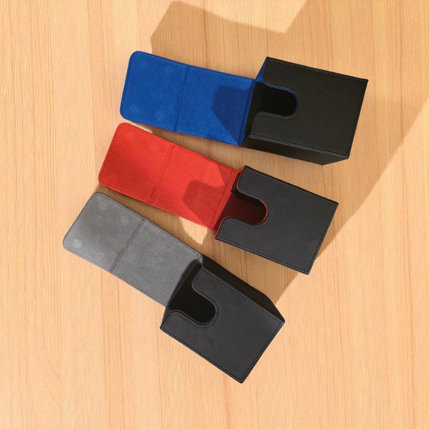three different colored leather wallet cases, each with a unique color and design, placed on a wooden surface.