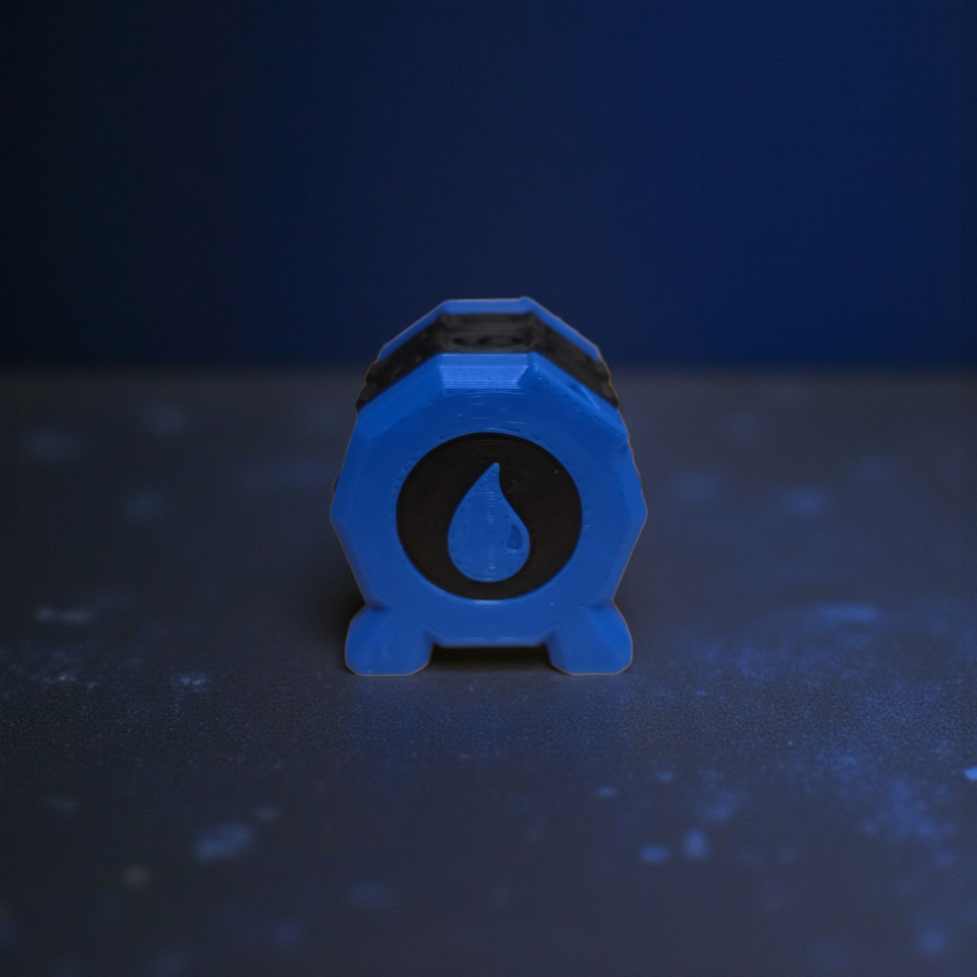 A blue hexagonal object with a black symbol on it, placed on a dark surface.
