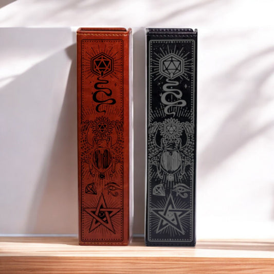 Two ornate leather-bound books with intricate designs and symbols on their covers are displayed against a white wall.