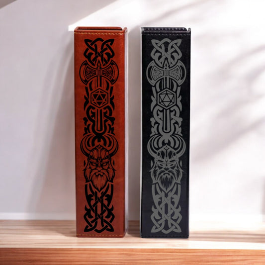 Two leather-bound books with intricate black and red designs on their covers stand side by side on a wooden surface.